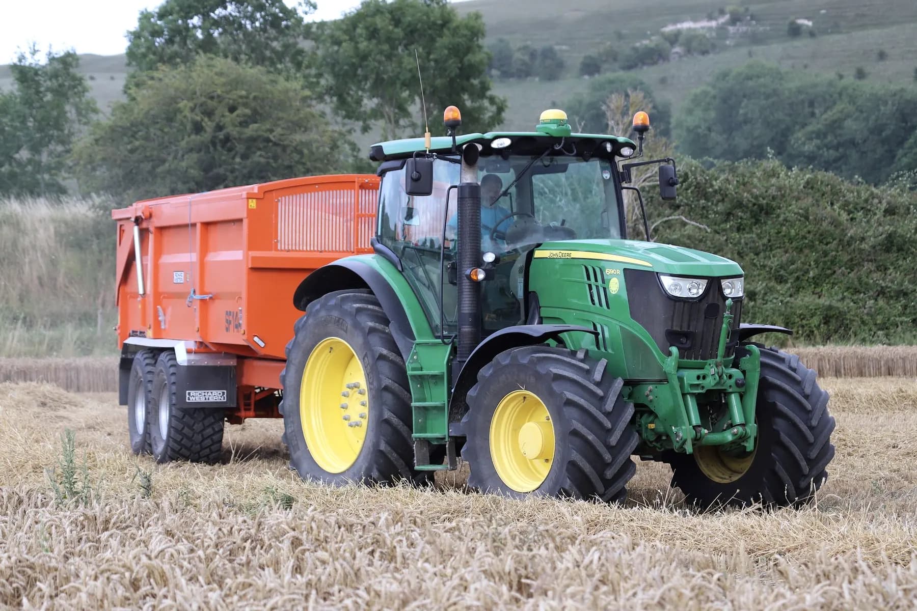 Landbouwkipper achter een tractor op een veldweg