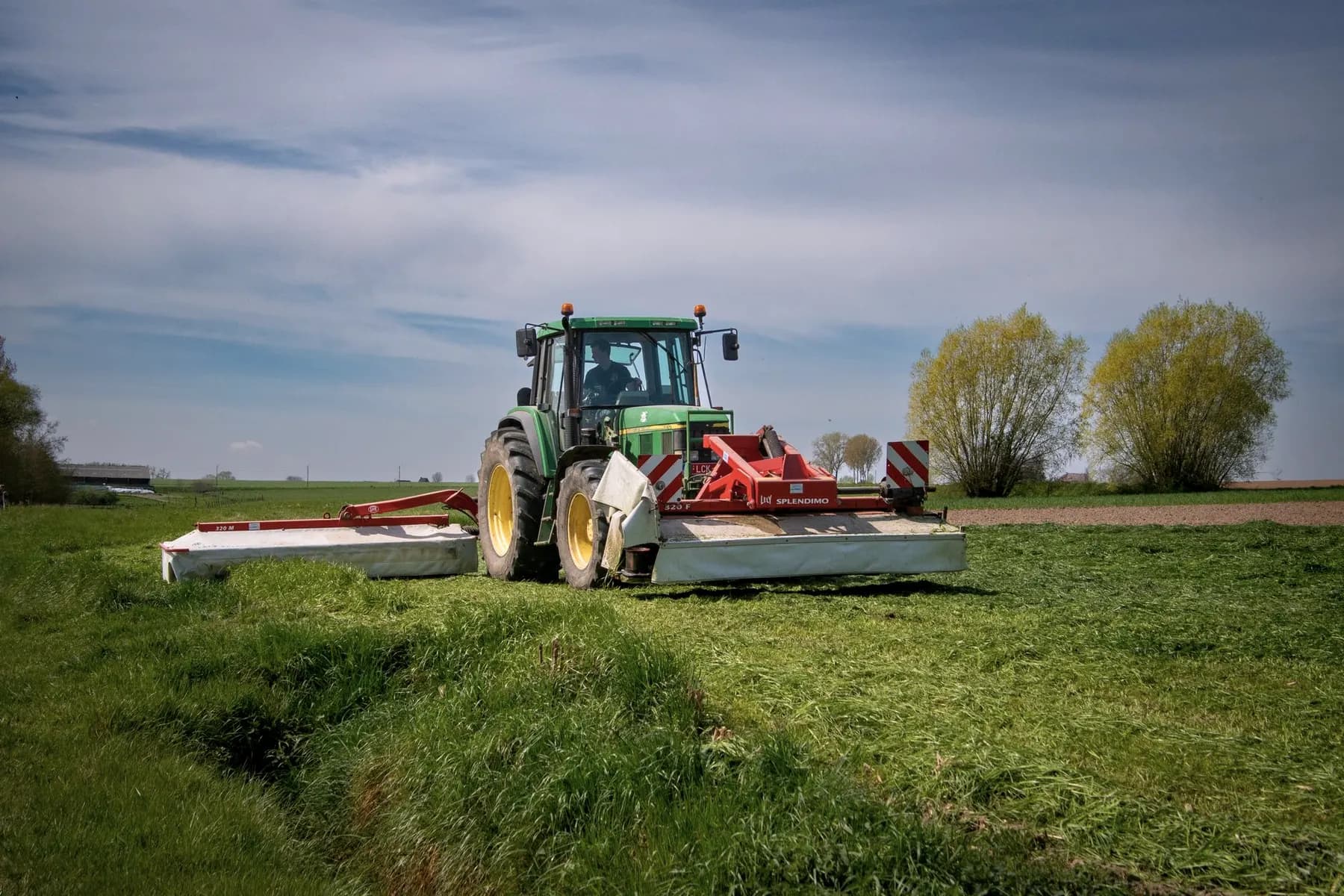 Schijvenmaaier die gras maait achter een tractor