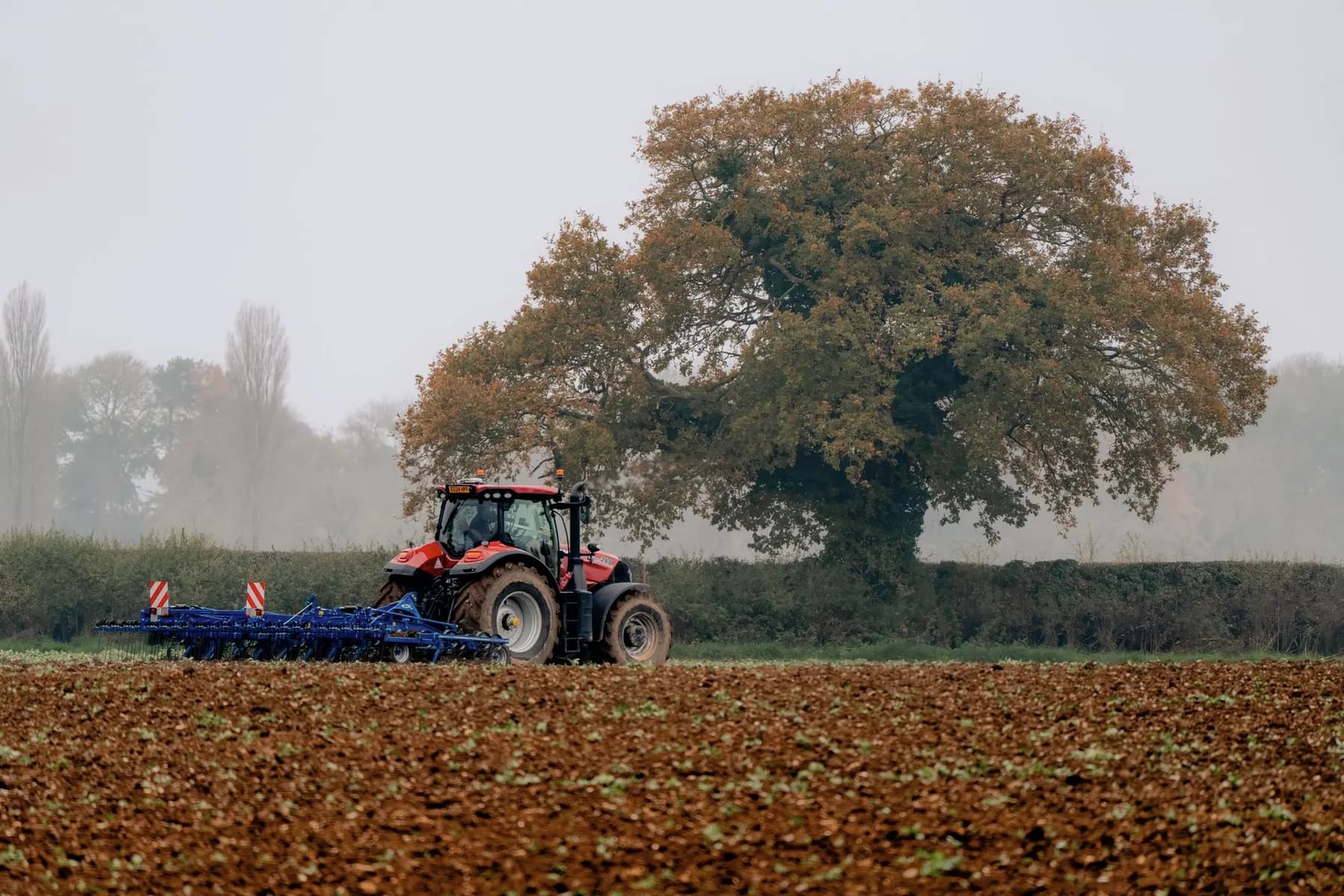 Wentelploeg met blinkende scharen achter een tractor