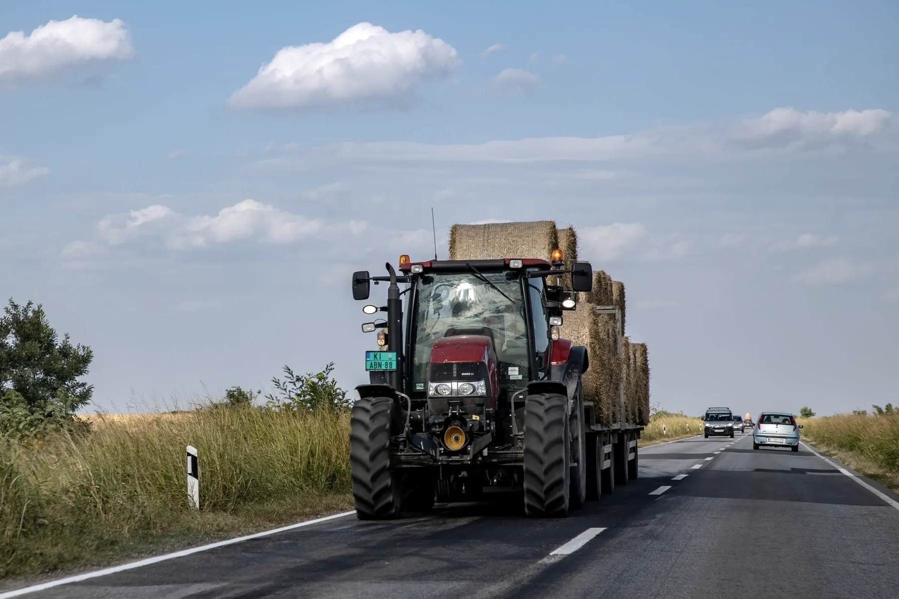 Tractor op een landelijke weg, van achteren gezien