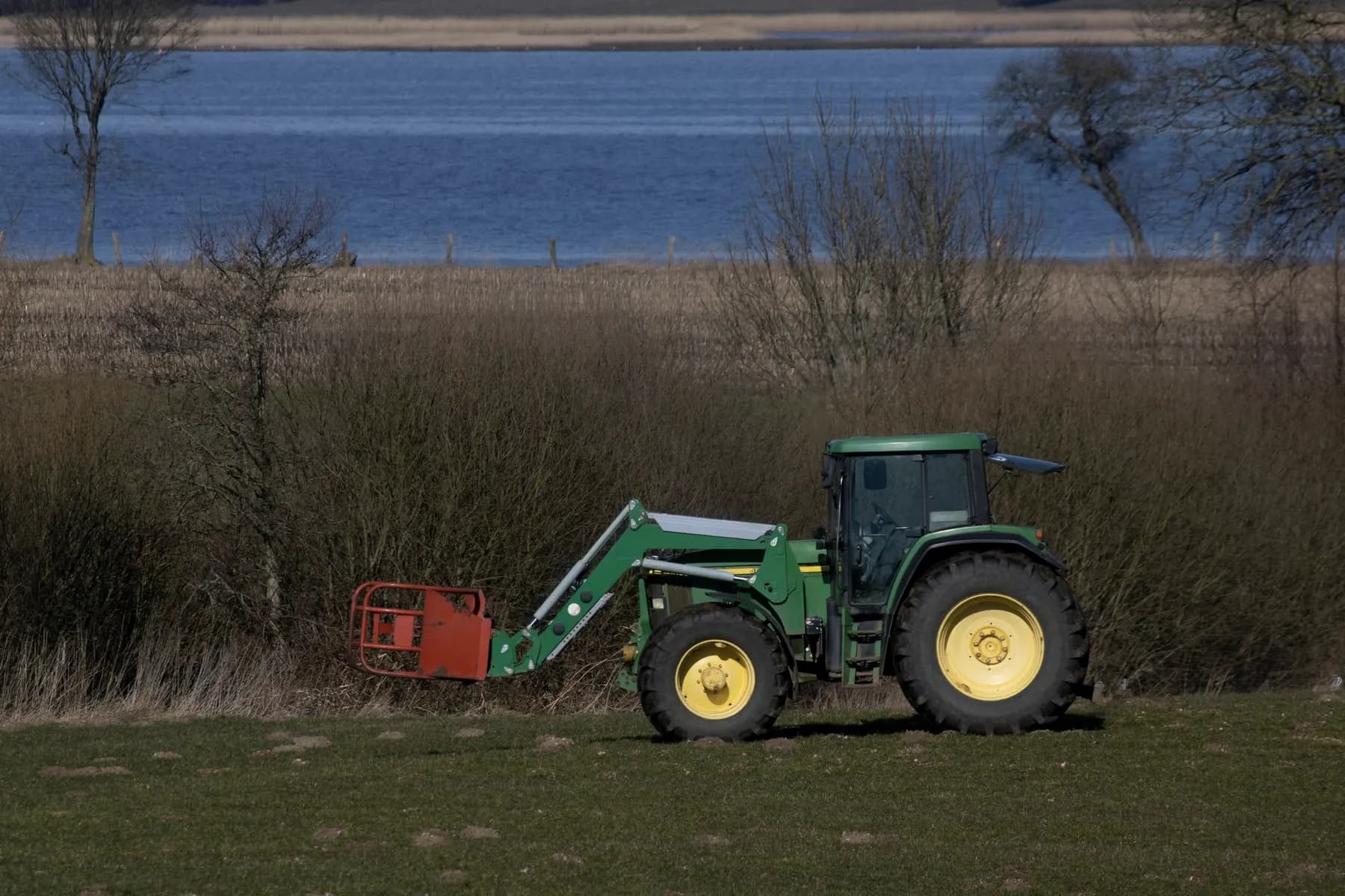 Compacttractor met voorlader op een grasveld