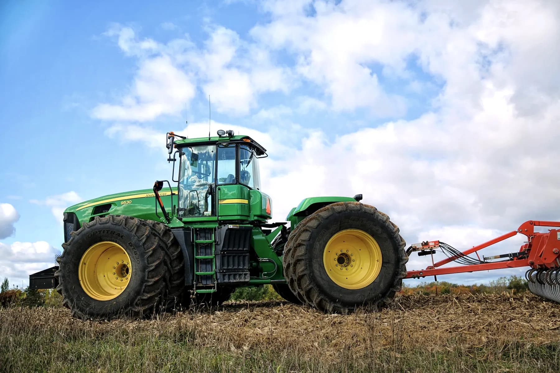 Grote landbouwtractor met dubbellucht achterbanden op een akker
